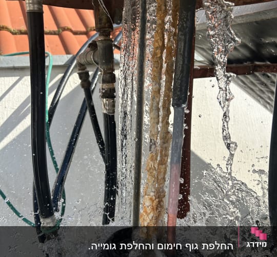 מים זורמים על צינורות דוד שמש עם חלודה